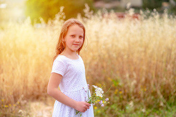 Fototapeta na wymiar Beautiful little girl blowing dandelion. Portrait adorable little kid outdoor. Summer or Autumn. Harvest. Shavuot.