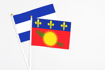 Guadeloupe and El Salvador stick flags on white background. High quality fabric, miniature national flag. Peaceful global concept.White floor for copy space.
