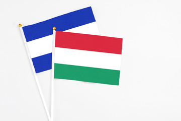 Hungary and El Salvador stick flags on white background. High quality fabric, miniature national flag. Peaceful global concept.White floor for copy space.