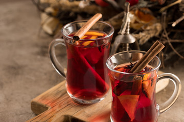 Two glasses of christmas mulled wine with oranges and spices on a textural background. Selective focus. Copy space.