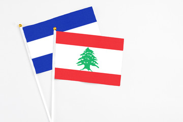 Lebanon and El Salvador stick flags on white background. High quality fabric, miniature national flag. Peaceful global concept.White floor for copy space.
