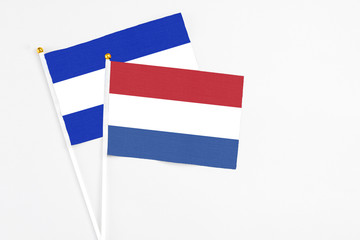 Netherlands and El Salvador stick flags on white background. High quality fabric, miniature national flag. Peaceful global concept.White floor for copy space.
