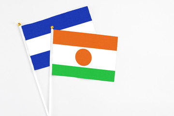 Niger and El Salvador stick flags on white background. High quality fabric, miniature national flag. Peaceful global concept.White floor for copy space.