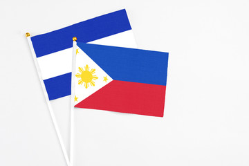 Philippines and El Salvador stick flags on white background. High quality fabric, miniature national flag. Peaceful global concept.White floor for copy space.