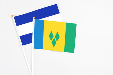 Saint Vincent And The Grenadines and El Salvador stick flags on white background. High quality fabric, miniature national flag. Peaceful global concept.White floor for copy space.