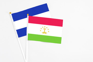 Tajikistan and El Salvador stick flags on white background. High quality fabric, miniature national flag. Peaceful global concept.White floor for copy space.
