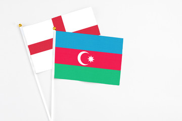 Azerbaijan and England stick flags on white background. High quality fabric, miniature national flag. Peaceful global concept.White floor for copy space.