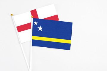 Curacao and England stick flags on white background. High quality fabric, miniature national flag. Peaceful global concept.White floor for copy space.