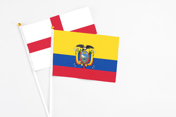 Ecuador and England stick flags on white background. High quality fabric, miniature national flag. Peaceful global concept.White floor for copy space.