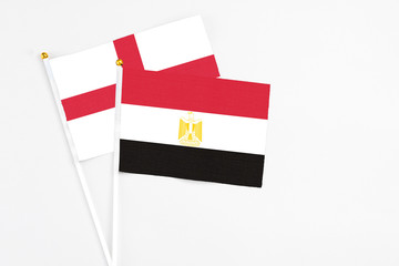 Egypt and England stick flags on white background. High quality fabric, miniature national flag. Peaceful global concept.White floor for copy space.