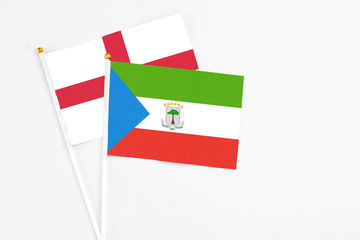 Equatorial Guinea and England stick flags on white background. High quality fabric, miniature national flag. Peaceful global concept.White floor for copy space.