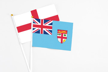 Fiji and England stick flags on white background. High quality fabric, miniature national flag. Peaceful global concept.White floor for copy space.