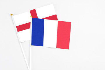 France and England stick flags on white background. High quality fabric, miniature national flag. Peaceful global concept.White floor for copy space.