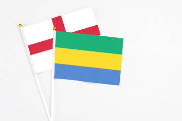 Gabon and England stick flags on white background. High quality fabric, miniature national flag....