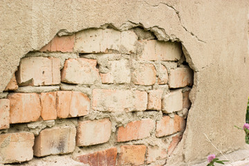 Non technology plaster. Building cracked plaster facade wall with brick.