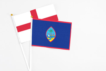 Guam and England stick flags on white background. High quality fabric, miniature national flag. Peaceful global concept.White floor for copy space.