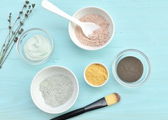 Different cosmetic clay, facial mask in bowls, natural skin treatment, top view.