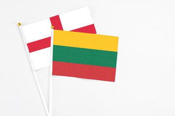 Lithuania and England stick flags on white background. High quality fabric, miniature national flag. Peaceful global concept.White floor for copy space.