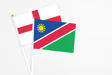 Namibia and England stick flags on white background. High quality fabric, miniature national flag. Peaceful global concept.White floor for copy space.