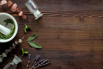 Apothecary of natural wellness and self-care. Herbs and medicine on dark wooden background top view...