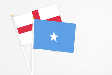 Somalia and England stick flags on white background. High quality fabric, miniature national flag. Peaceful global concept.White floor for copy space.
