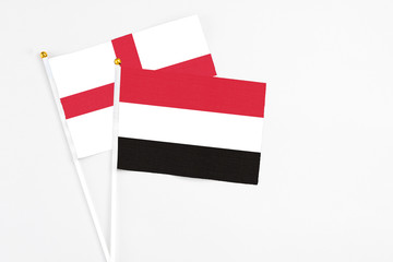 Yemen and England stick flags on white background. High quality fabric, miniature national flag. Peaceful global concept.White floor for copy space.