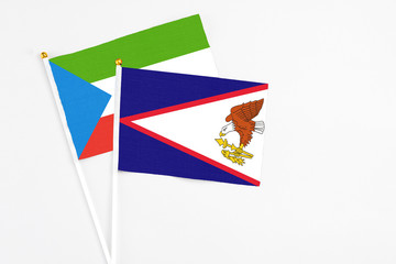 American Samoa and Equatorial Guinea stick flags on white background. High quality fabric, miniature national flag. Peaceful global concept.White floor for copy space.