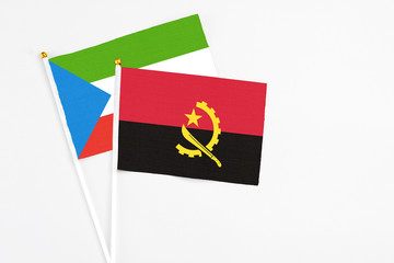 Angola and Equatorial Guinea stick flags on white background. High quality fabric, miniature national flag. Peaceful global concept.White floor for copy space.