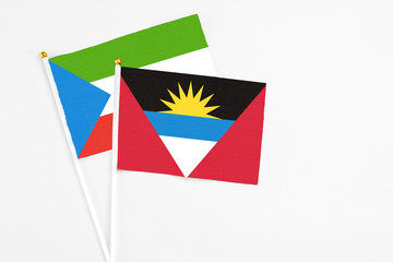 Antigua and Barbuda and Equatorial Guinea stick flags on white background. High quality fabric, miniature national flag. Peaceful global concept.White floor for copy space.