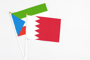 Bahrain and Equatorial Guinea stick flags on white background. High quality fabric, miniature national flag. Peaceful global concept.White floor for copy space.