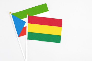 Bolivia and Equatorial Guinea stick flags on white background. High quality fabric, miniature national flag. Peaceful global concept.White floor for copy space.
