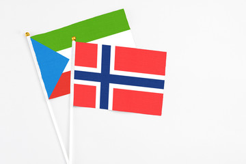 Obraz premium Bouvet Islands and Equatorial Guinea stick flags on white background. High quality fabric, miniature national flag. Peaceful global concept.White floor for copy space.