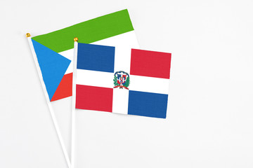 Dominican Republic and Equatorial Guinea stick flags on white background. High quality fabric, miniature national flag. Peaceful global concept.White floor for copy space.
