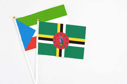 Dominica and Equatorial Guinea stick flags on white background. High quality fabric, miniature national flag. Peaceful global concept.White floor for copy space.