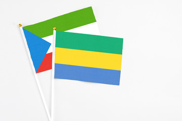 Gabon and Equatorial Guinea stick flags on white background. High quality fabric, miniature national flag. Peaceful global concept.White floor for copy space.