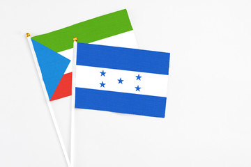 Honduras and Equatorial Guinea stick flags on white background. High quality fabric, miniature national flag. Peaceful global concept.White floor for copy space.
