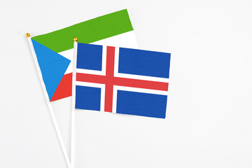 Obraz premium Iceland and Equatorial Guinea stick flags on white background. High quality fabric, miniature national flag. Peaceful global concept.White floor for copy space.