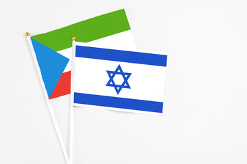 Israel and Equatorial Guinea stick flags on white background. High quality fabric, miniature national flag. Peaceful global concept.White floor for copy space.