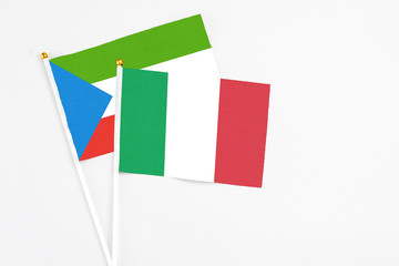 Italy and Equatorial Guinea stick flags on white background. High quality fabric, miniature national flag. Peaceful global concept.White floor for copy space.