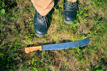 he has a man in leather boots and a large machete knife