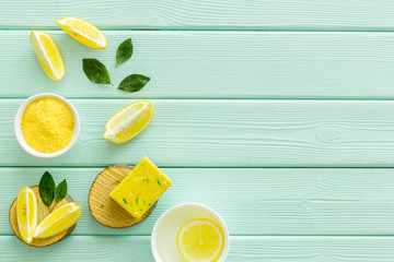 Lemon cosmetics. Cleansing tonic and handmade soap on green wooden background top view frame copy...