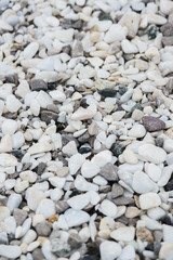 light white and gray decorative pebbles for landscape design, close up view from angle above vertical stock photo image background with selective focus