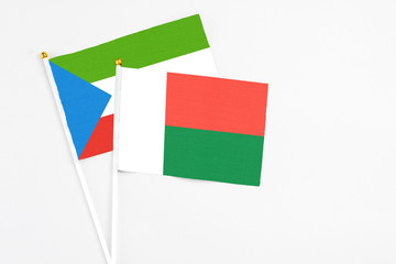 Madagascar and Equatorial Guinea stick flags on white background. High quality fabric, miniature national flag. Peaceful global concept.White floor for copy space.