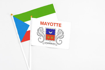 Mayotte and Equatorial Guinea stick flags on white background. High quality fabric, miniature national flag. Peaceful global concept.White floor for copy space.