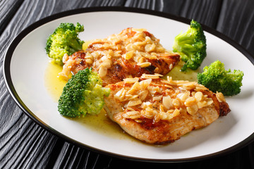 Festive fried chicken fillet with almonds served with broccoli close-up on a plate. horizontal