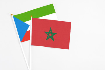 Morocco and Equatorial Guinea stick flags on white background. High quality fabric, miniature national flag. Peaceful global concept.White floor for copy space.