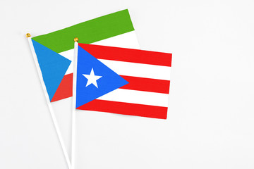Puerto Rico and Equatorial Guinea stick flags on white background. High quality fabric, miniature national flag. Peaceful global concept.White floor for copy space.