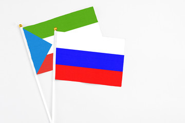 Russia and Equatorial Guinea stick flags on white background. High quality fabric, miniature national flag. Peaceful global concept.White floor for copy space.