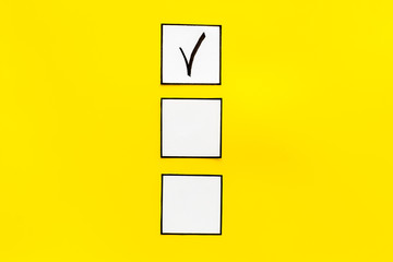 Check mark in check-box on yellow background top view copy space