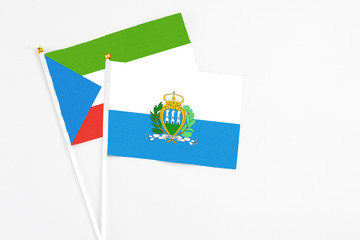 San Marino and Equatorial Guinea stick flags on white background. High quality fabric, miniature national flag. Peaceful global concept.White floor for copy space.